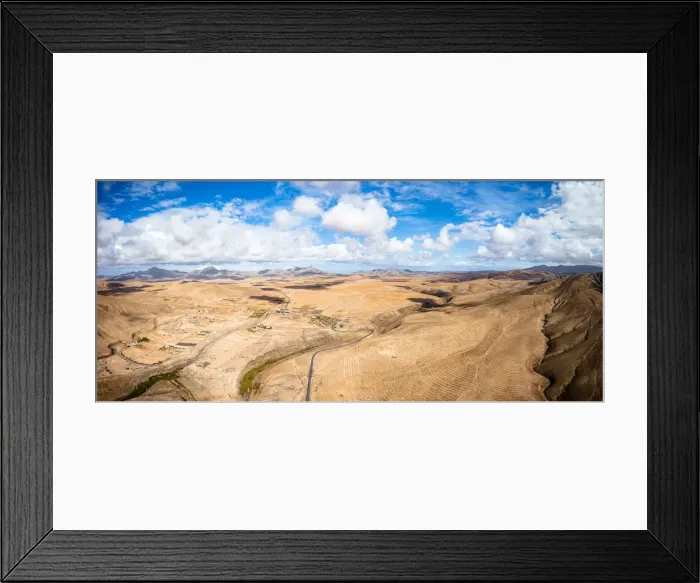 Framed Print : Aerial view of desert landscape and mountains crossed by asphalt road, Tefia Framed Print : Aerial view of desert landscape and mountains crossed by asphalt road, Tefia