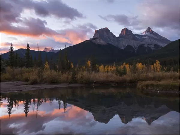 Colourful sunrise over Three Sisters at Policeman Creek in autumn, Canmore, Banff