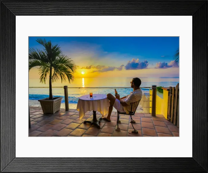 Framed Print : Man enjoying a beverage on a patio at sunset in Turks and Caicos Islands, Atlantic Framed Print : Man enjoying a beverage on a patio at sunset in Turks and Caicos Islands, Atlantic