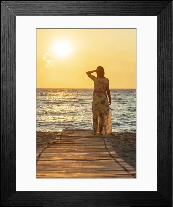 Framed Print : Charming woman contemplating the sea at sunset standing on Matala beach, Crete Framed Print : Charming woman contemplating the sea at sunset standing on Matala beach, Crete