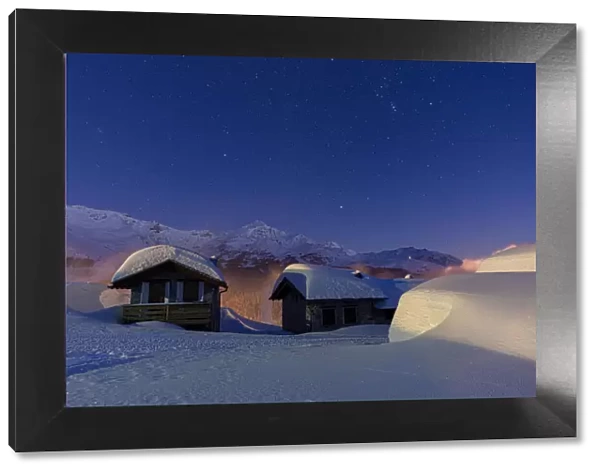 Mountain huts covered with snow during a winter starry night, Andossi, Madesimo
