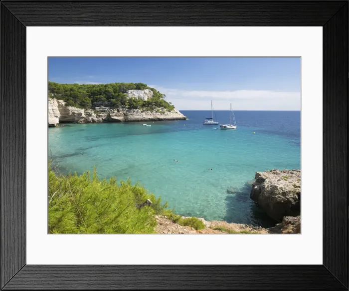 Framed Print : View over the turquoise waters of Cala Mitjana to pine-clad limestone cliffs