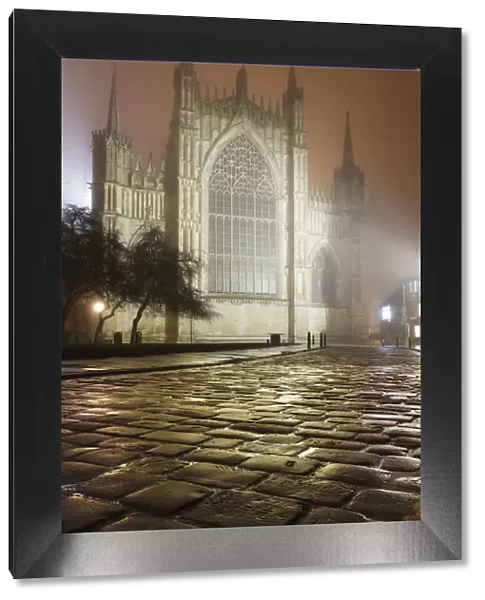 An atmospheric misty mid-winter view of York Minsters East window after dark, York, Yorkshire, England, United Kingdom, Europe