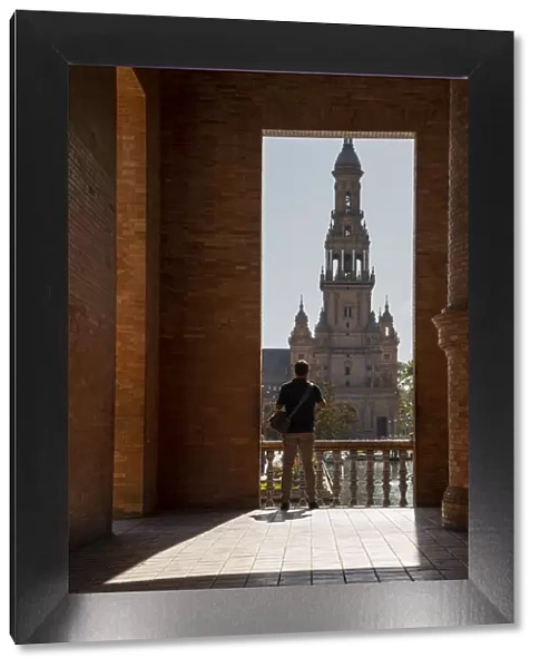Man enjoying the view of Plaza de Espana, framed through an archway, Seville, Andalusia, Spain, Europe