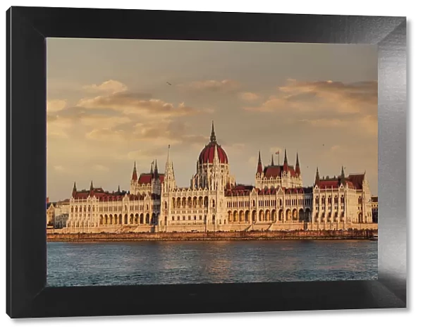 Orszaghaz Parliament neo-Gothic building and River Danube view at sunset, with clouds above, UNESCO World Heritage Site, Budapest, Hungary, Europe