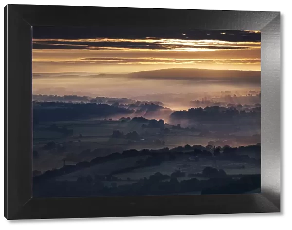 Morning sunbeams and early morning fog cover the Cheshire Plain at sunrise, from Bosley Cloud, Cheshire, England, United Kingdom, Europe