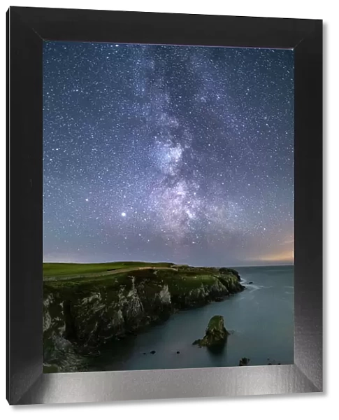 The Milky Way and night sky over Gwenfaens Pillar, Porth Saint, near Rhoscolyn, Anglesey, North Wales, United Kingdom, Europe