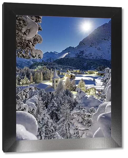 Full moon over Chiesa Bianca covered with snow surrounded by woods, Maloja, Bregaglia Valley, Engadine, Canton of Graubunden, Switzerland, Europe