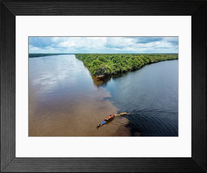Framed Print : Little boat on the meeting point of the Casiquiare River and black Pasimoni River, in the deep south of Venezuela, South America Framed Print : Little boat on the meeting point of the Casiquiare River and black Pasimoni River, in the deep south of Venezuela, South America