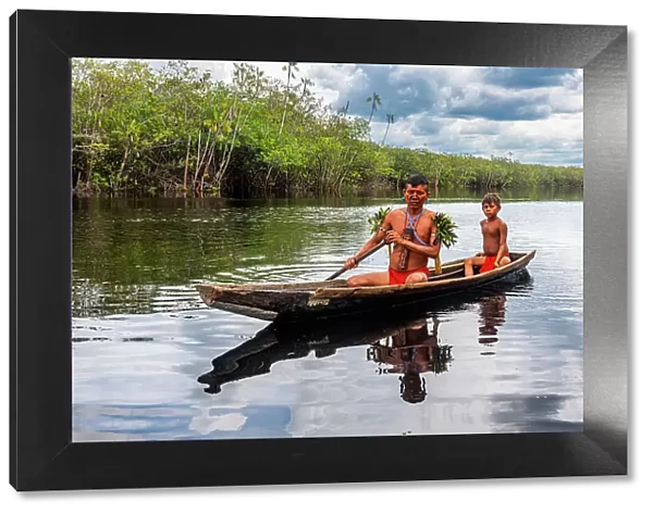 Father and son from the Yanomami tribe in a canoe, southern Venezuela, South America