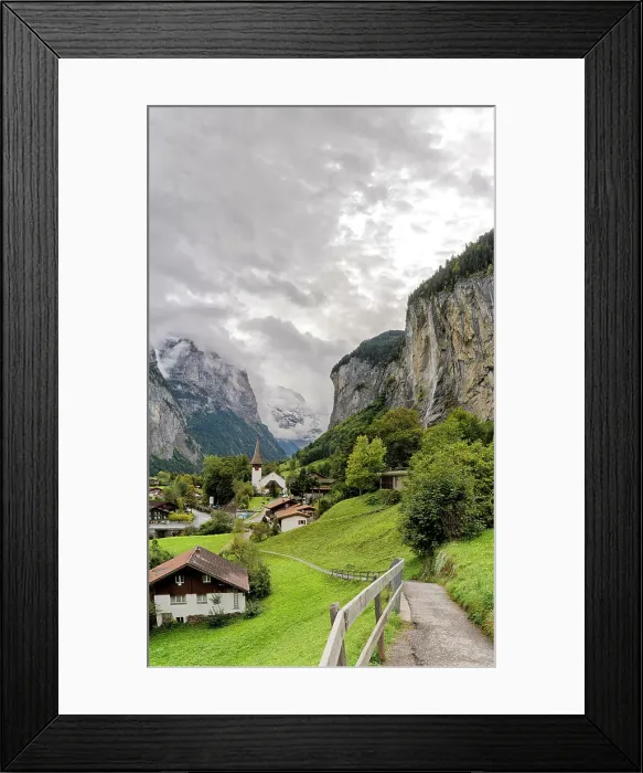 Framed Print : Path among green meadows of the alpine village of Lauterbrunnen with Trummelbach Falls in the background, Bern canton, Switzerland, Europe