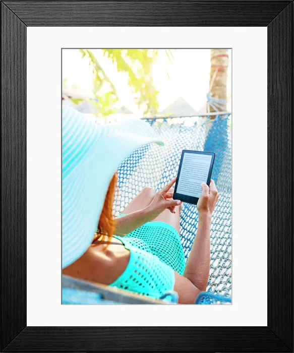 Framed Print : Cheerful woman on a hammock enjoying reading a digital book on tablet, Zanzibar, Tanzania, East Africa, Africa