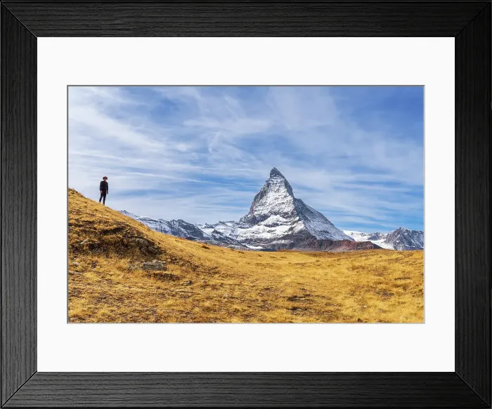 Framed Print : Hiker stands in front of the iconic shape of Matterhorn among yellow grasses, Riffelalp, Zermatt, Valais Canton, Swiss Alps, Switzerland, Europe Framed Print : Hiker stands in front of the iconic shape of Matterhorn among yellow grasses, Riffelalp, Zermatt, Valais Canton, Swiss Alps, Switzerland, Europe