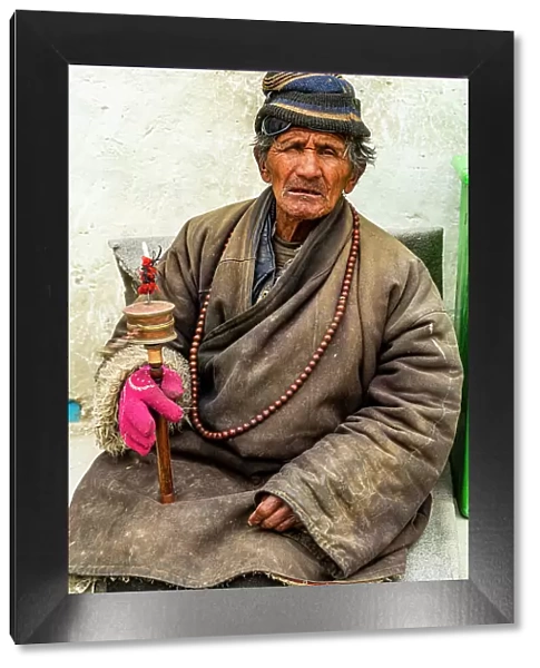 Old man with a prayer wheel in his hand, Kingdom of Mustang, Nepal, Asia