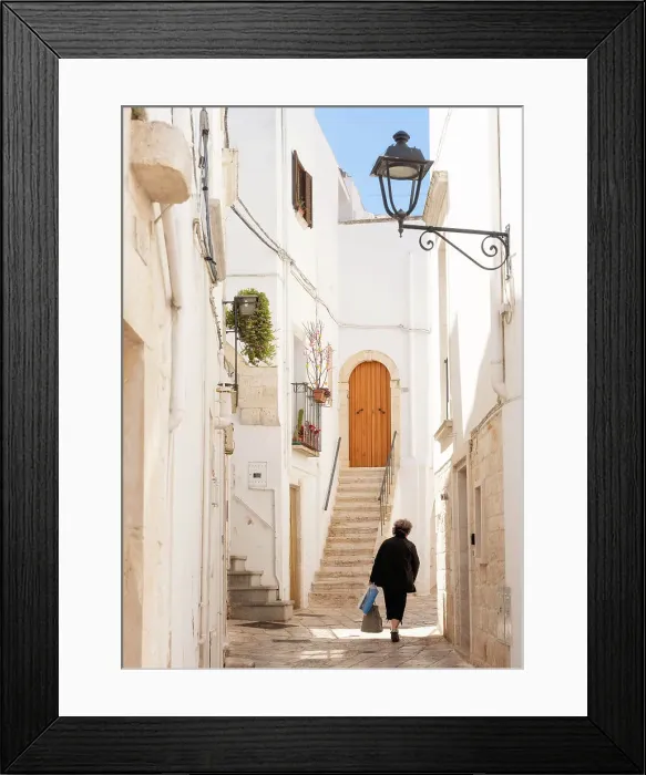 Framed Print : Woman walking in a narrow street in the Old Town, Locorotondu, Puglia, Italy, Europe