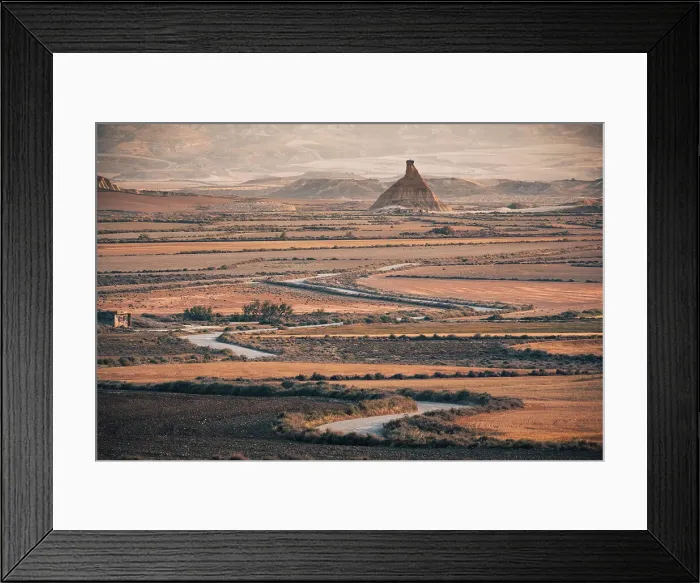 Framed Print : The badlands of Bardenas Reales at sunrise with a winding road leading towards the Castildetierra rock formation, Navarre, Spain, Europe Framed Print : The badlands of Bardenas Reales at sunrise with a winding road leading towards the Castildetierra rock formation, Navarre, Spain, Europe