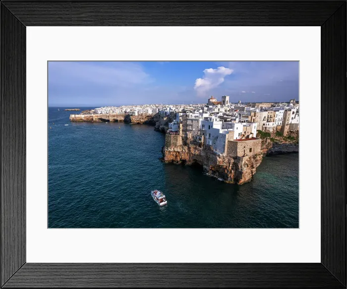Framed Print : Aerial view of a boat sailing off the coast of Polignano a Mare fishing village, Bari, Apulia, Adriatic Sea, Mediterranean Sea, Italy, Europe Framed Print : Aerial view of a boat sailing off the coast of Polignano a Mare fishing village, Bari, Apulia, Adriatic Sea, Mediterranean Sea, Italy, Europe