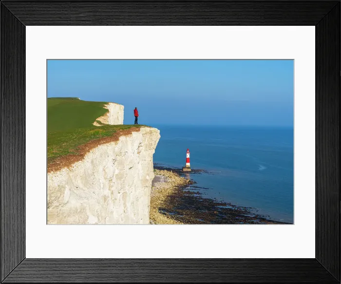 Framed Print : Tourist stands on top of the cliff overlooking Beachy Head lighthouse, Seven Sisters chalk cliffs, South Downs National Park, East Sussex, England, United Kingdom, Europe Framed Print : Tourist stands on top of the cliff overlooking Beachy Head lighthouse, Seven Sisters chalk cliffs, South Downs National Park, East Sussex, England, United Kingdom, Europe
