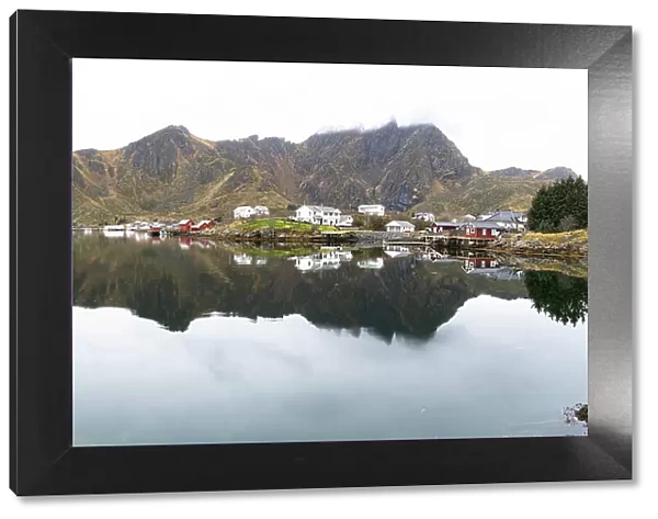 Fishing village of Ballstad and mountains mirrored in the calm waters of a fjord, Vestvagoy, Lofoten Islands, Nordland, Norway, Scandinavia, Europe