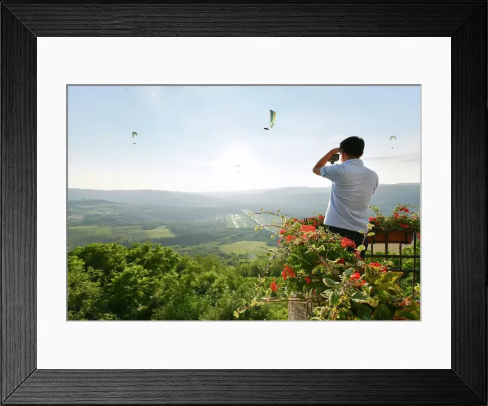 Framed Print : A tourist photographs paragliders from atop the hilltop village of Motovun, Istria, Croatia, Europe