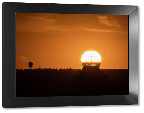 The sun aligned at sunrise with an airport control tower, Spain, Europe