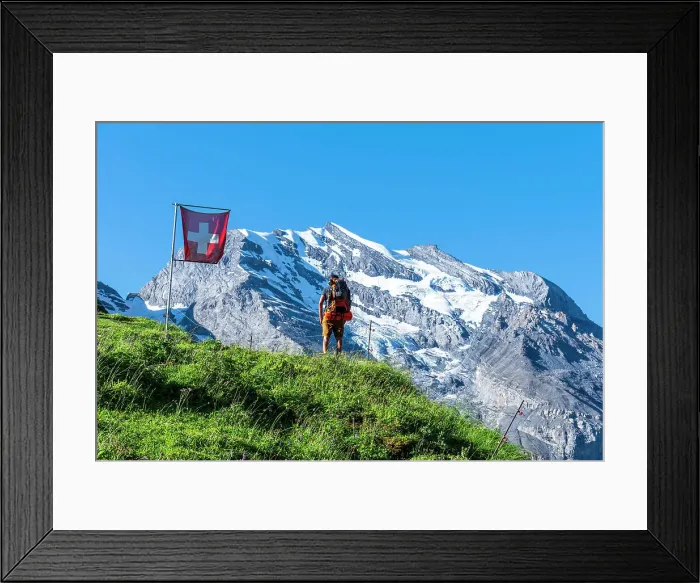 Framed Print : Rear view of a man with backpack hiking the Swiss Alps passing a Swiss flag flying, Oeschinensee, Kandersteg, Bern Canton, Switzerland, Europe Framed Print : Rear view of a man with backpack hiking the Swiss Alps passing a Swiss flag flying, Oeschinensee, Kandersteg, Bern Canton, Switzerland, Europe