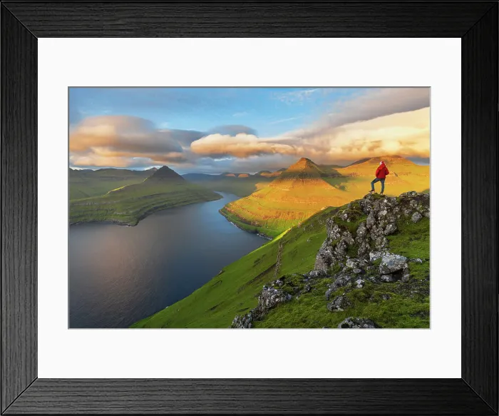 Framed Print : Summer view of a hiker standing on top of a mountain overlooking the fjord at sunrise, Funningur fjord, Eysturoy island, Faroe islands, Denmark, Europe Framed Print : Summer view of a hiker standing on top of a mountain overlooking the fjord at sunrise, Funningur fjord, Eysturoy island, Faroe islands, Denmark, Europe