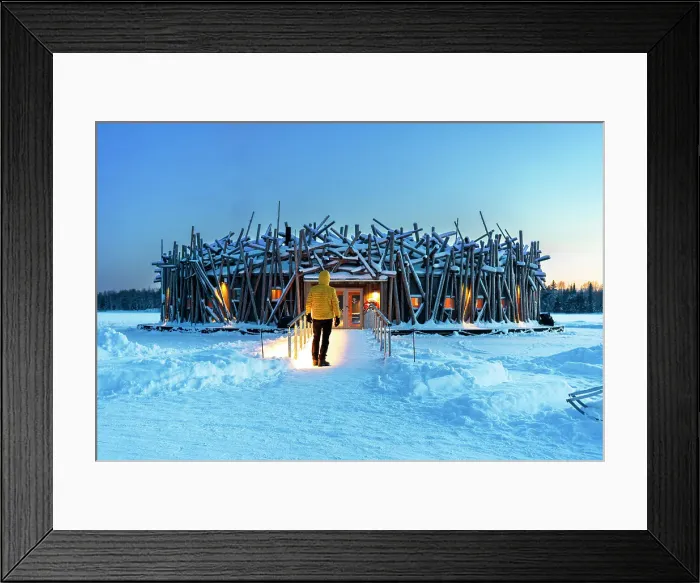 Framed Print : Person stands on the bridge connecting the main building of the illuminated Arctic Bath hotel made of logs, dusk time, Harads, Swedish Lapland, Norrbotten, Sweden, Scandinavia, Europe