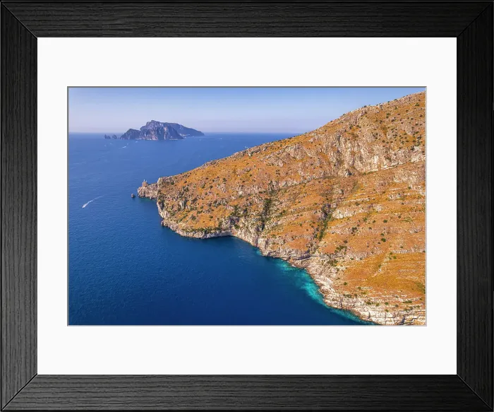 Framed Print : Aerial view of a rocky coast facing the blue water of the Tyrrhenian Sea with the island of Capri in the background, Amalfi Coast, Naples province, Campania region, South of Italy, Italy, Europe Framed Print : Aerial view of a rocky coast facing the blue water of the Tyrrhenian Sea with the island of Capri in the background, Amalfi Coast, Naples province, Campania region, South of Italy, Italy, Europe
