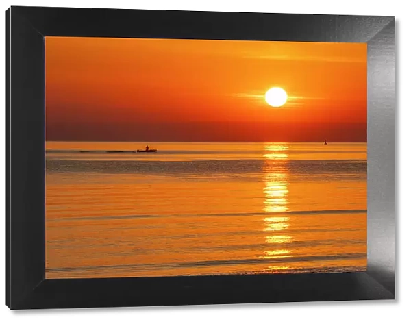View of sunrise reflecting in the sea from Rimini Beach, Rimini, Emilia-Romagna, Italy, Europe