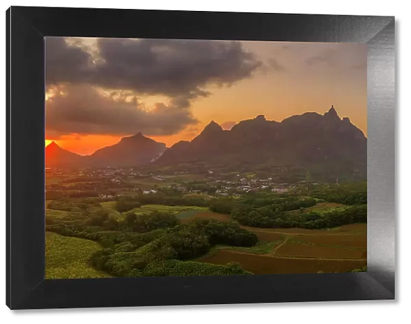 View of golden sunset behind Long Mountain and patchwork of green fields, Mauritius, Indian Ocean, Africa