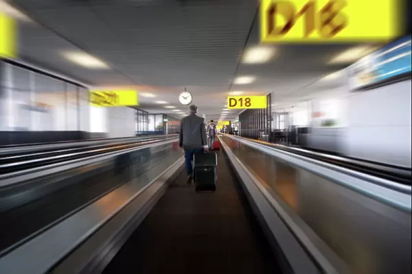 Businessman with luggage on travelator at Schiphol airport, Amsterdam, Netherlands