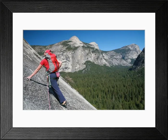 Framed Print : A rock climber ascends slabs at the base of the huge cliff known as The Apron