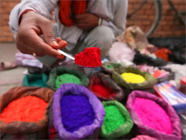 A dye trader offers his brightly coloured wares in a roadside stall in Kathmandu
