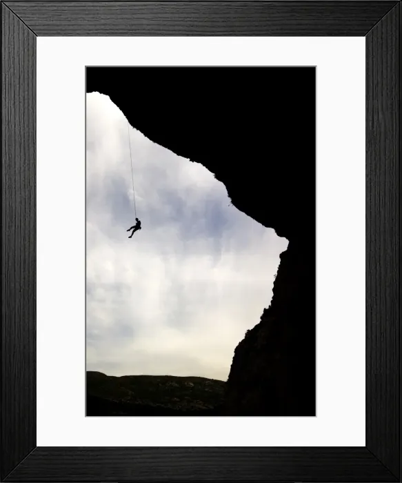 Framed Print : A climber is lowered from a the edge of a huge cave in the Mascun Gorge Framed Print : A climber is lowered from a the edge of a huge cave in the Mascun Gorge