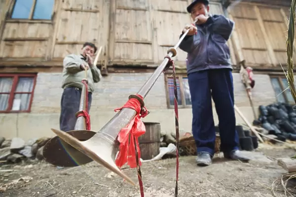 Men playing traditional horn instruments at a Lunar New Year festival in the Miao village of Qingman, Guizhou Province
