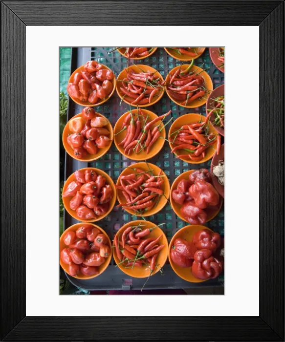 Framed Print : Colourful red chillies and capsicums on orange plates on a market stall in Kuching Framed Print : Colourful red chillies and capsicums on orange plates on a market stall in Kuching