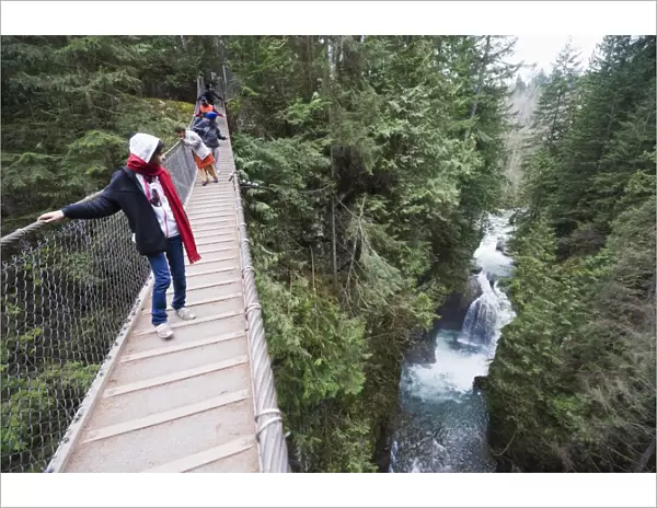 Tourists on a suspension bridge in Lynn Canyon Park, Vancouver, British Columbia, Canada