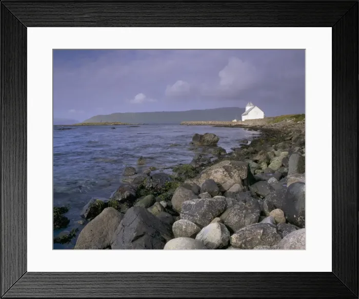 Framed Print : Kirkjubour, church and rocky shoreline, Hestur in the distance, Streymoy Framed Print : Kirkjubour, church and rocky shoreline, Hestur in the distance, Streymoy