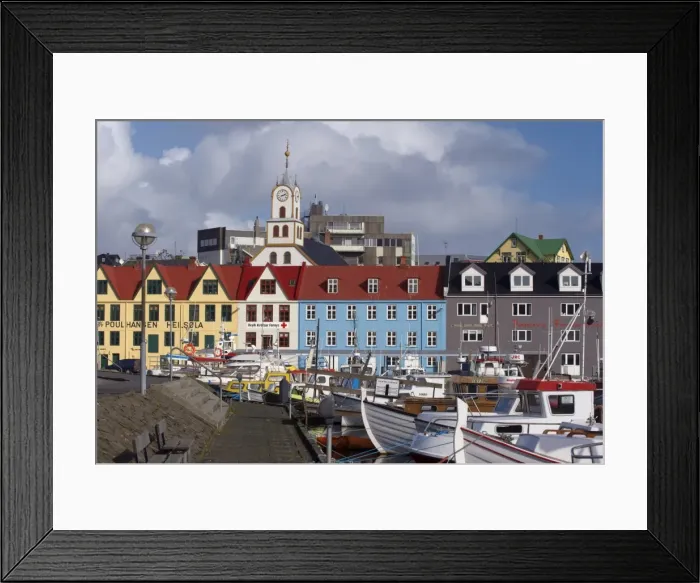Framed Print : Colourful boats and picturesque gabled buildings along the quayside in Vestaravag harbour Framed Print : Colourful boats and picturesque gabled buildings along the quayside in Vestaravag harbour