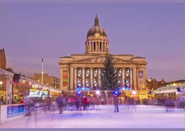 Ice skaters on the temporary Christmas outdoor ice skating rink in the Old Market Square in front of the Council House in the city centre, Nottingham, Nottinghamshire, England, United