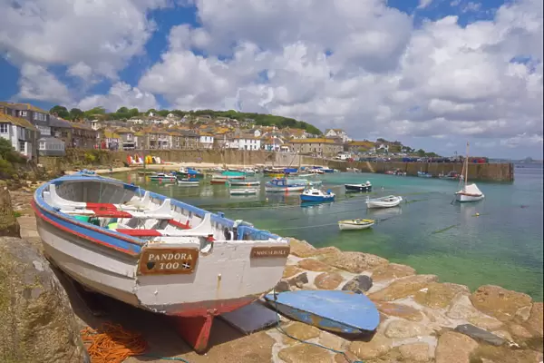 Small boat on the quay and small boats in the enclosed harbour at Mousehole