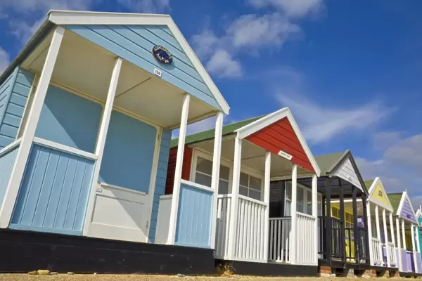 Brightly painted beach huts in the afternoon sunshine, on the seafront promenade