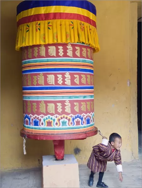 Young boy pulling a prayer wheel, Jakar Dzong, Castle of the White Bird