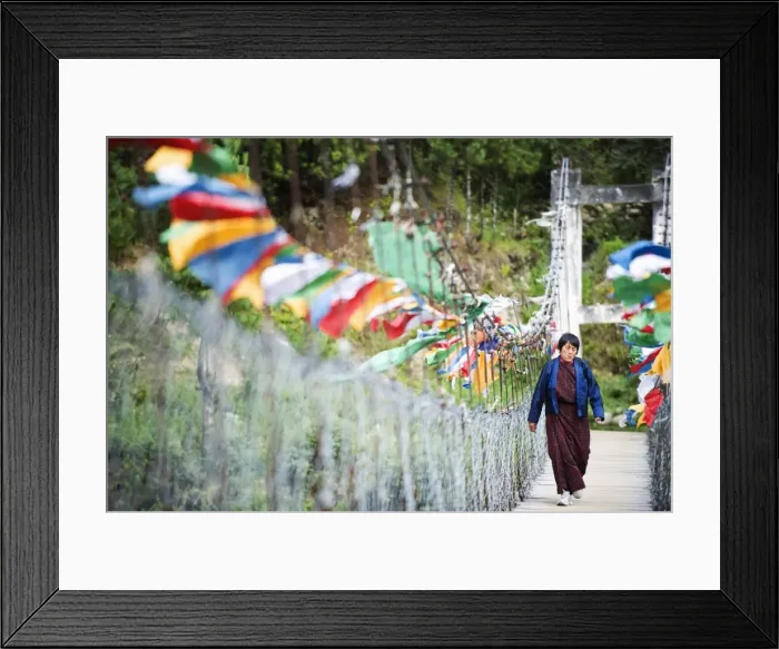 Framed Print : Local woman crossing a bridge covered in prayer flags, Bumthang, Chokor Valley Framed Print : Local woman crossing a bridge covered in prayer flags, Bumthang, Chokor Valley