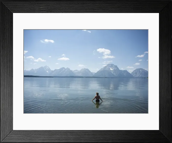 Framed Print : Woman wades in lake with Tetons in distance, Grand Teton National Park Framed Print : Woman wades in lake with Tetons in distance, Grand Teton National Park