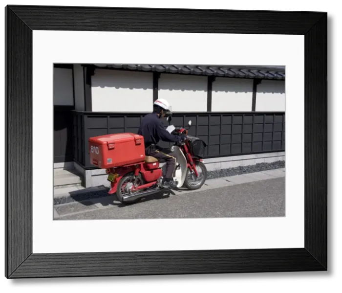 Framed Print : A Japanese postman riding a typical red scooter making his rounds, Japan, Asia Framed Print : A Japanese postman riding a typical red scooter making his rounds, Japan, Asia
