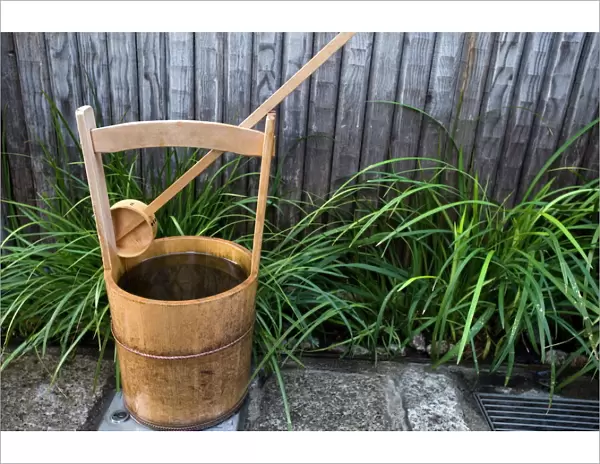 Traditional Japanese wooden bucket and ladle for washing sidewalk in a custom called uchimizu