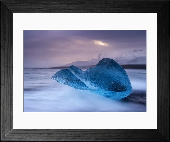 Framed Print : Translucent blue iceberg washed ashore on Breidamerkursandur black sands Framed Print : Translucent blue iceberg washed ashore on Breidamerkursandur black sands