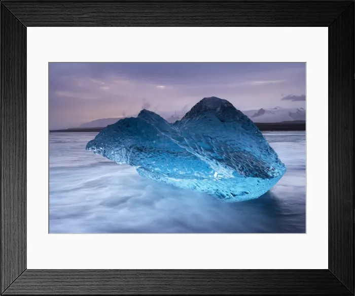 Framed Print : Translucent blue iceberg washed ashore on Breidamerkursandur black sands Framed Print : Translucent blue iceberg washed ashore on Breidamerkursandur black sands